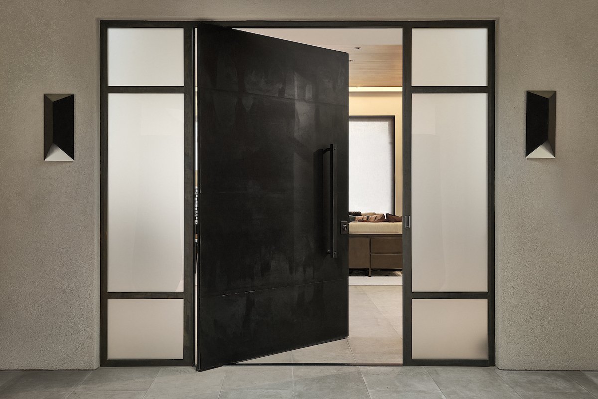 Exterior or entrance pivot doors can be made from all sorts of materials, like this black, custom steel. Design by Castle Wood Doors. FritsJurgens System M pivot hinge.