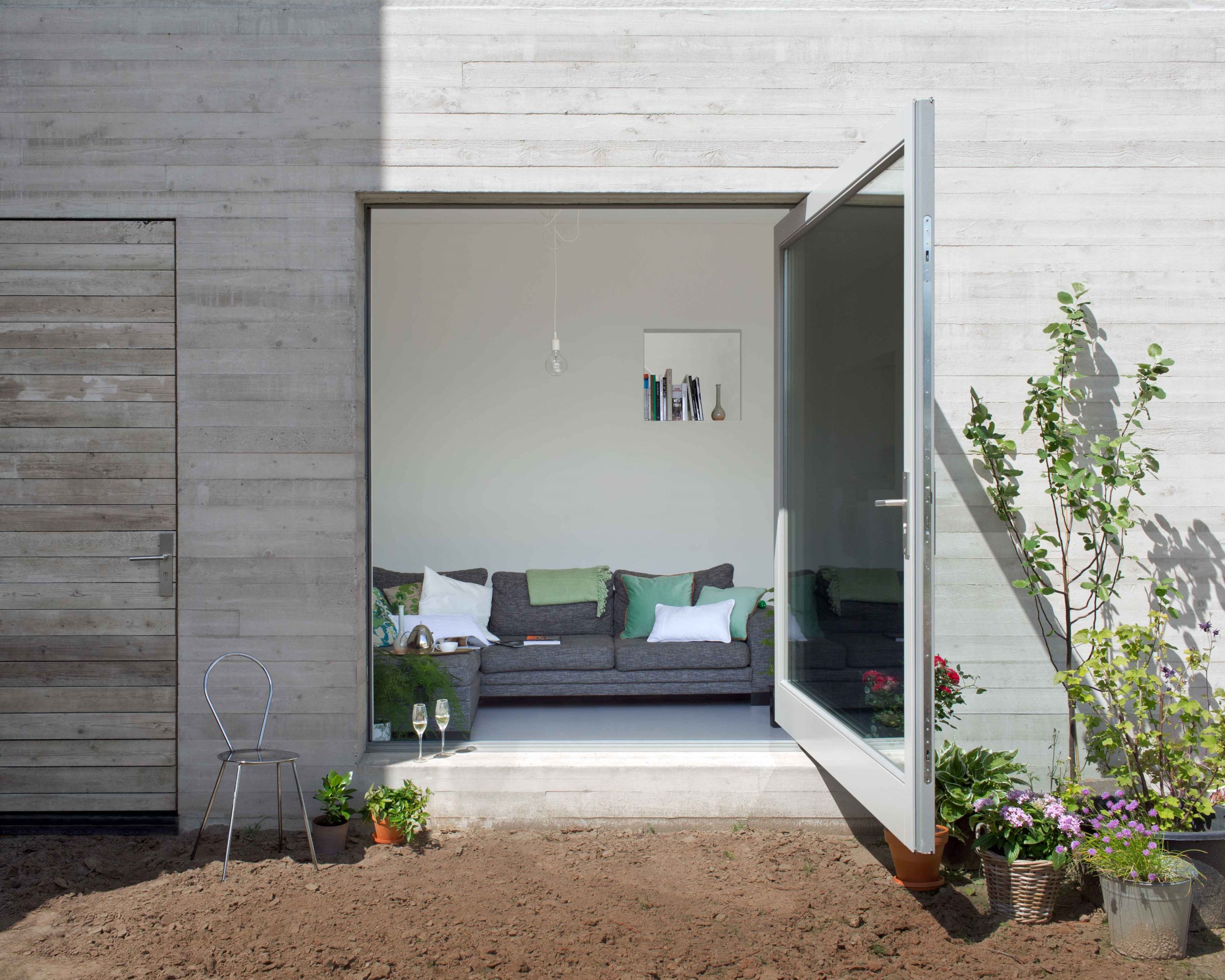 grande-porta-a-bilico-in-vetro-verso-il-giardino-con-telaio-in-acciaio-bianco-fritsjurgens-1-scaled.jpg
